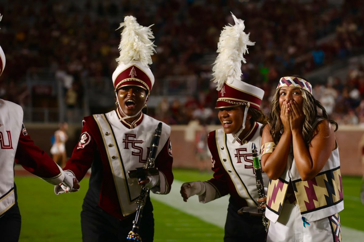 Three members of the Marching Chiefs react with surprise and awe.