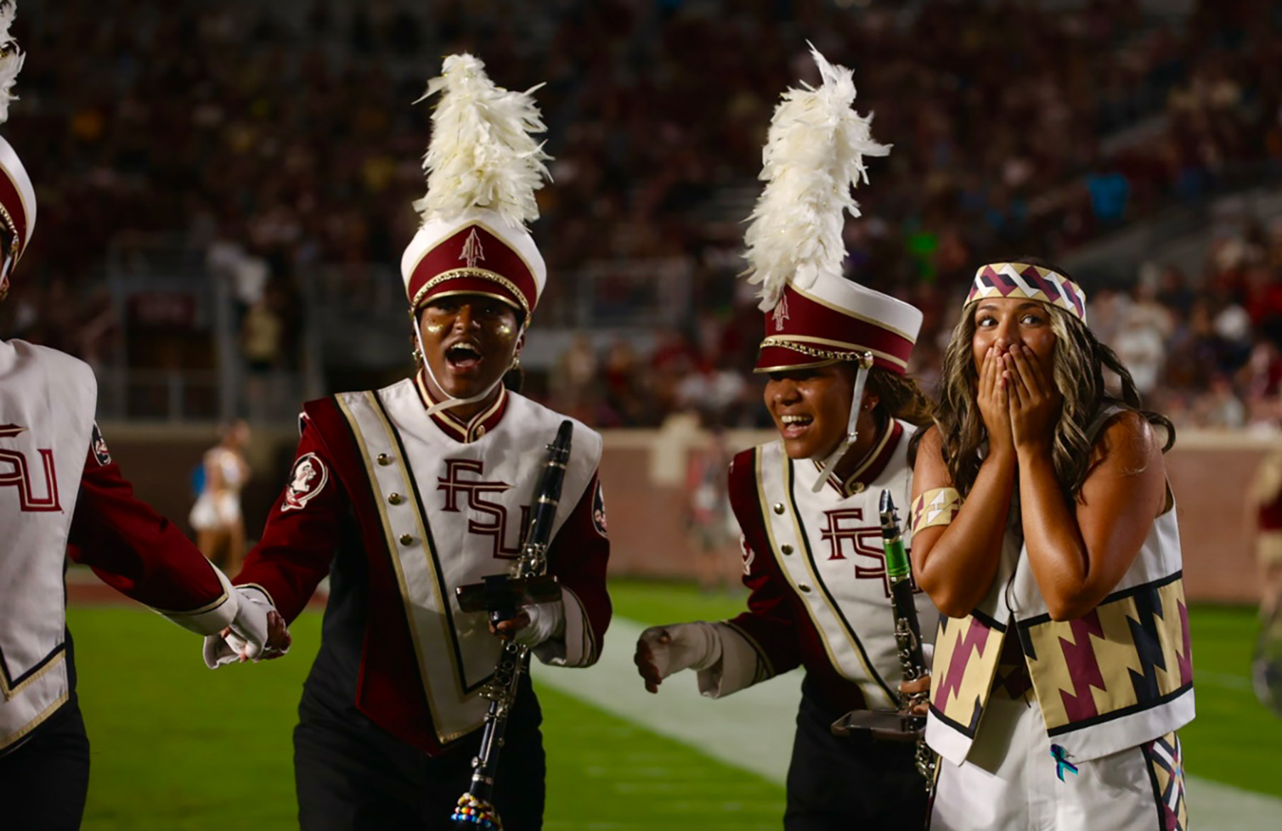 Three members of the Marching Chiefs react with surprise and awe.