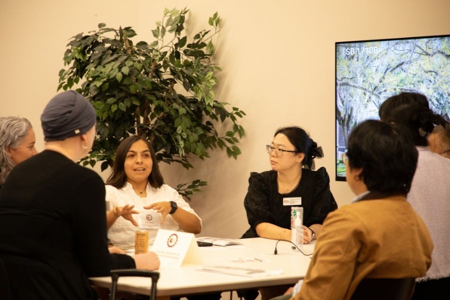 Participants gather around a table for a small-group discussion during FSU’s Collaborative Collision event on artificial intelligence and interdisciplinary research.