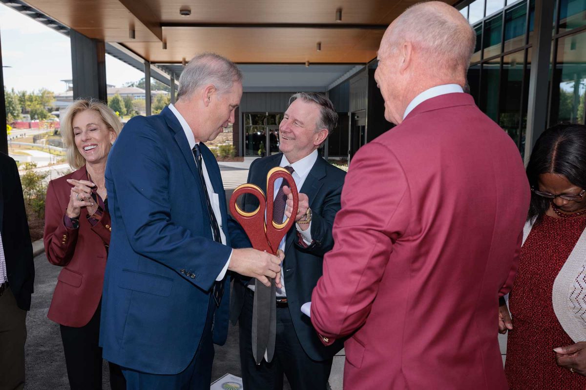 FSU President Richard McCullough shakes hands with Florida Commissioner of Agriculture Wilton Simpson alongside university officials and trustees after they cut the ribbon on the new Wilton Simpson FSU Health Research and Collaboration Building on Oct. 30, 2026. (Bill Lax/Florida State University)