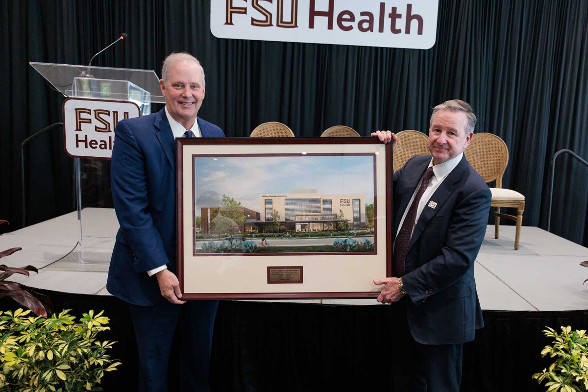 FSU President Richard McCullough presents Florida Commissioner of Agriculture Wilton Simpson a framed artist’s rendering of the new Wilton Simpson FSU Health Research and Collaboration Building on Oct. 30, 2026. (Bill Lax/Florida State University)