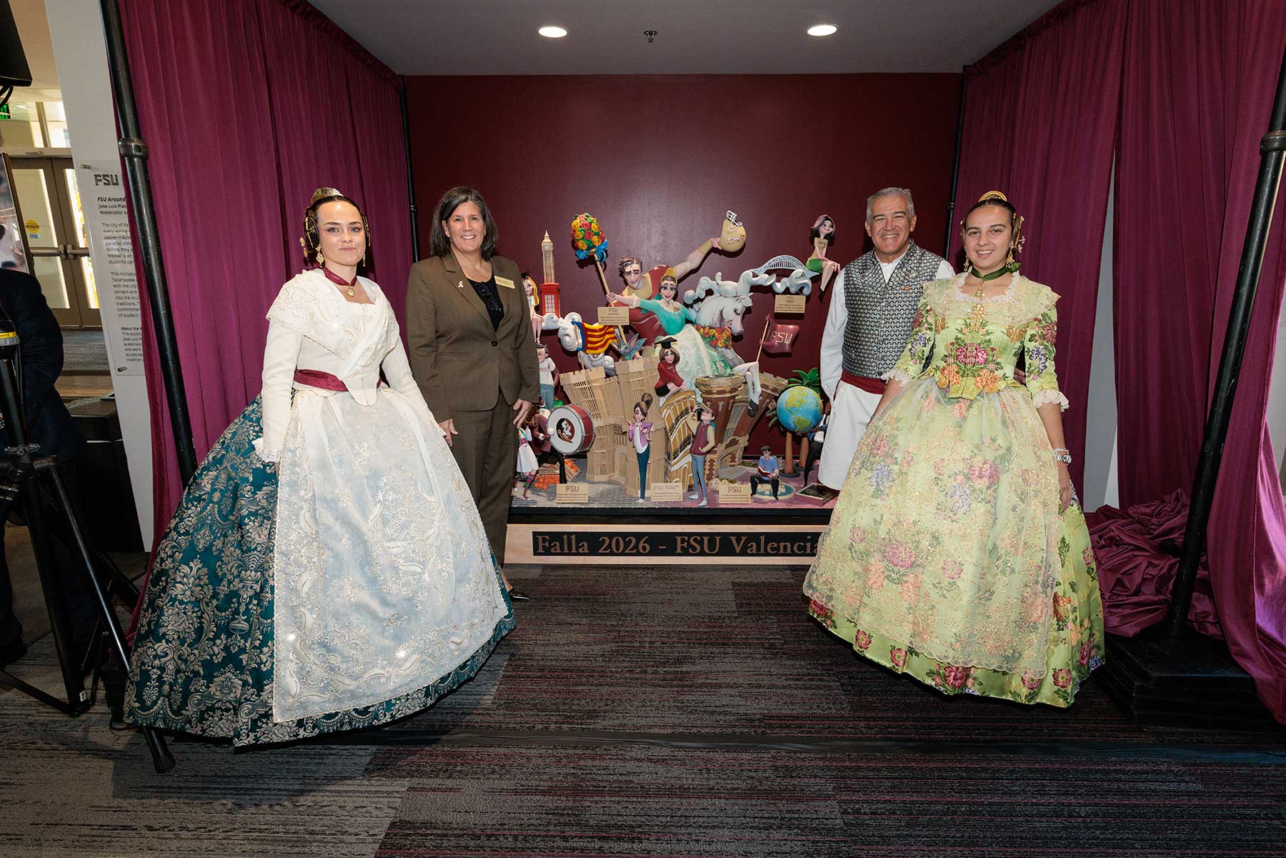 Two paper stand on either side of a fallas sculpture.