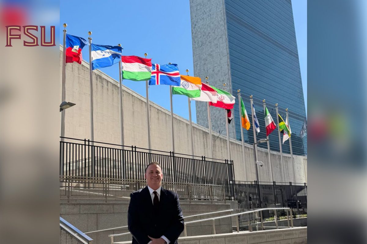 FSU Vice President and Chief Information Officer Jonathan Fozard stands outside United Nations headquarters in New York City, with international flags and the UN Secretariat building behind him.