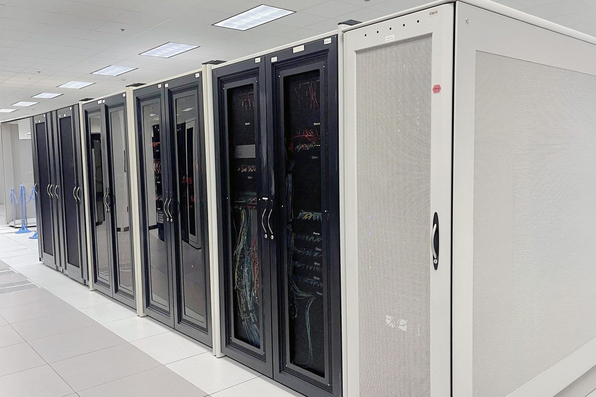A row of server cabinets housing computer equipment and network cables inside the Northwest Regional Data Center.